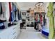 This walk-in closet has multiple rows of shelving for clothing and accessories and a central chandelier at 8525 Saint Marlo Fairway Way, Duluth, GA 30097