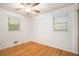 Comfortable bedroom featuring hardwood floors, ceiling fan, and ample natural light from two windows at 890 Oriole Se Ln, Marietta, GA 30067