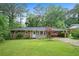Charming brick ranch-style home with a well-manicured lawn and lush greenery at 890 Oriole Se Ln, Marietta, GA 30067