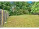 Large, green backyard with mature trees and wood fence at 3035 Landington Way, Duluth, GA 30096
