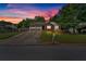 Charming home featuring a two-car garage, brick accents, manicured lawn and inviting curb appeal at dusk at 3035 Landington Way, Duluth, GA 30096