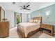 This bedroom has a ceiling fan, a bed with lots of pillows, carpeted floors, and a light blue accent wall at 1205 Mcclelen Way, Decatur, GA 30033