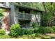 Two-story condo with brick accents and a covered balcony overlooking lush landscaping at 1205 Mcclelen Way, Decatur, GA 30033