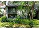Two-story condo with brick accents and a covered balcony surrounded by lush landscaping at 1205 Mcclelen Way, Decatur, GA 30033