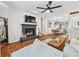 A cozy living room with a brick fireplace, wood floors, and an open view to the dining area at 1205 Mcclelen Way, Decatur, GA 30033