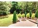 Beautiful backyard with a brick patio, stone fire pit, and lush landscaping at 149 Stargrass Way, Grayson, GA 30017