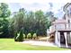 A landscaped backyard featuring green grass, mature trees, and a patio at 149 Stargrass Way, Grayson, GA 30017