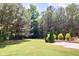 Serene backyard featuring a lush lawn, mature trees, and a stone patio perfect for outdoor relaxation and entertaining at 149 Stargrass Way, Grayson, GA 30017