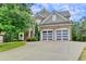 Exterior view of a two-story home featuring stone accents and a spacious two-car garage at 149 Stargrass Way, Grayson, GA 30017