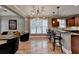 Charming view of a kitchen with an island bar and stylish lighting fixtures, seamlessly connected to the living space at 149 Stargrass Way, Grayson, GA 30017