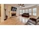 Inviting living room featuring a fireplace, leather sofas, hardwood floors, and windows at 149 Stargrass Way, Grayson, GA 30017