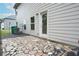 Stone patio with door entry, small window, and air conditioner on the side of the home at 2272 Gateway Trl, Ellenwood, GA 30294