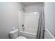 Bright bathroom features a shower and tub combination with a gray curtain and a white toilet at 2272 Gateway Trl, Ellenwood, GA 30294