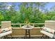 Serene balcony with seating and table, perfect for enjoying peaceful wooded views at 25305 Plantation Ne Dr, Atlanta, GA 30324