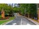 Community entrance with directional signage, lush landscaping, and privacy gates at 25305 Plantation Ne Dr, Atlanta, GA 30324