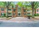 Beautiful brick condo building featuring mature trees and black shutters and doors at 25305 Plantation Ne Dr, Atlanta, GA 30324