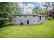 View of the backyard showing the home's exterior, green lawn, and surrounding trees at 3920 Stonewall Tell Rd, Atlanta, GA 30349