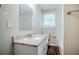 A clean bathroom with a granite countertop, a window, wood floor, and a tub at 3920 Stonewall Tell Rd, Atlanta, GA 30349