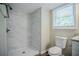 Bathroom features marble-look shower, toilet, new vanity, and natural light at 3920 Stonewall Tell Rd, Atlanta, GA 30349