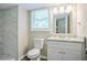 Bathroom features marble-look shower, new vanity, toilet, and window at 3920 Stonewall Tell Rd, Atlanta, GA 30349