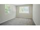 Sunlit bedroom featuring carpeted flooring and two windows providing ample natural light at 3920 Stonewall Tell Rd, Atlanta, GA 30349