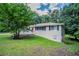 View of home showing beautiful lawn, large tree and side entrance at 3920 Stonewall Tell Rd, Atlanta, GA 30349