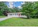 Charming single-story home featuring a well-manicured lawn, a red door, and a cozy front porch at 3920 Stonewall Tell Rd, Atlanta, GA 30349