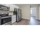 Updated kitchen features stainless steel appliances, granite countertops, and wood-look vinyl flooring at 3920 Stonewall Tell Rd, Atlanta, GA 30349