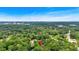 A distant cityscape is visible from this aerial view of a home surrounded by lush, green trees at 450 S Susan Creek Dr, Stone Mountain, GA 30083