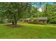 Charming one-story home with brick accents and a spacious, tree-shaded front lawn at 450 S Susan Creek Dr, Stone Mountain, GA 30083