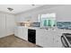 Bright kitchen features white cabinets, modern appliances, and stylish tile backsplash at 450 S Susan Creek Dr, Stone Mountain, GA 30083