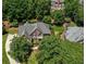 Aerial view showcasing a brick home with a well-maintained yard, mature trees, and inviting curb appeal at 935 Brookline Way, Alpharetta, GA 30022