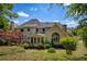 A sunny backyard featuring lush landscaping, including mature trees and shrubs, of the home exterior at 935 Brookline Way, Alpharetta, GA 30022