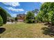 Expansive backyard with mature trees, ample lawn space, and patio furniture on a concrete patio at 935 Brookline Way, Alpharetta, GA 30022
