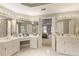 Spacious bathroom featuring dual vanities with white cabinets, tiled floors and a view of the bedroom at 935 Brookline Way, Alpharetta, GA 30022