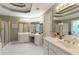 Bathroom showcasing dual sinks, white cabinets, tiled floors, and a glass-door shower at 935 Brookline Way, Alpharetta, GA 30022