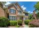 Beautiful two-story brick home featuring a charming balcony, lush landscaping, and classic architectural details at 935 Brookline Way, Alpharetta, GA 30022