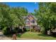 Charming two-story brick home with lush landscaping, mature trees, and a small balcony, creating a welcoming curb appeal at 935 Brookline Way, Alpharetta, GA 30022