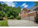 A brick home featuring an attached two-car garage with a large driveway and well-maintained lawn and landscaping at 935 Brookline Way, Alpharetta, GA 30022