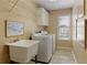 Bright laundry room features a utility sink, overhead cabinet and shelving, plus a front-load washer and dryer at 935 Brookline Way, Alpharetta, GA 30022