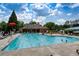 A sparkling community pool with lounge chairs, umbrellas, and people enjoying a refreshing swim on a sunny day at 935 Brookline Way, Alpharetta, GA 30022