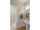 Charming powder room with a pedestal sink, decorative mirror, and textured wallpaper with tile flooring in the adjoined bathroom at 935 Brookline Way, Alpharetta, GA 30022