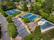 Aerial view featuring tennis courts and a pool, surrounded by lush landscaping and mature trees at 935 Brookline Way, Alpharetta, GA 30022