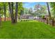 Wide shot of a spacious backyard with lush green grass, trees, and a firepit with adirondack chairs at 1091 Napier Se St, Atlanta, GA 30316