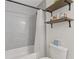 Bathroom with a white subway tile, tub and shower combination and open shelving at 1995 Raleigh Tavern Dr, Roswell, GA 30076