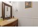 Stylish half bathroom with bronze fixtures, granite counter and wainscotting at 1995 Raleigh Tavern Dr, Roswell, GA 30076