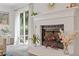 Close-up of the white brick fireplace with hearth, mantle, and sliding glass doors to backyard deck at 1995 Raleigh Tavern Dr, Roswell, GA 30076