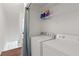 Bright laundry room with washer, dryer, and ample shelf space at 1995 Raleigh Tavern Dr, Roswell, GA 30076