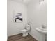 Clean half-bathroom with modern fixtures, pedestal sink, toilet, and decorative artwork at 210 Sharon Ln, Loganville, GA 30052