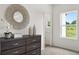 Charming bedroom with gray dresser, decorative mirror, and a view of nature through the window at 210 Sharon Ln, Loganville, GA 30052